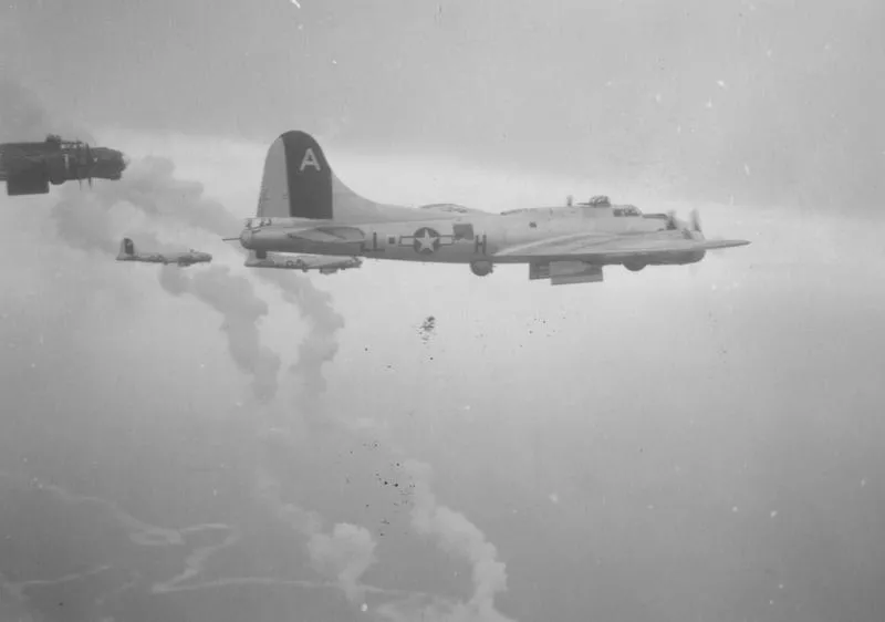 B-17 Flying Fortresses, including (LL-H, serial number 41-2447) nicknamed "Kickapoo", of the 91st Bomb Group bomb a target during a mission. Image stamped on reverse: 'Not for publication for personal use only. Passed by US army examiner 10143.'